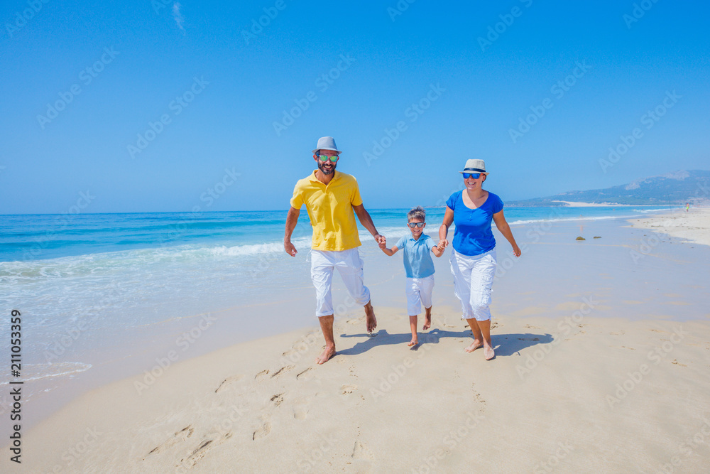 Family having fun and running on a sandy beach Family having fun and running on a sandy beach