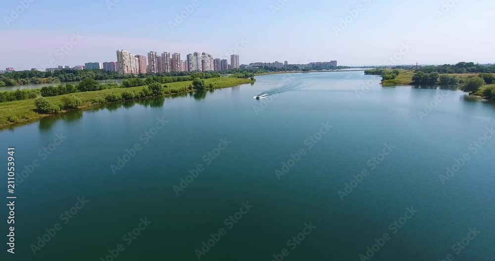 The boat goes along the river and stops. In the background a beautiful view of the city. Drone 4k The boat goes along the river and stops. In the background a beautiful view of the city. Drone 4k