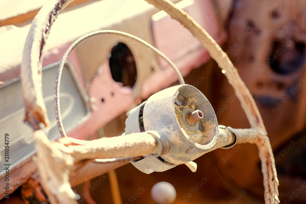Inside cab view with rusty steering wheel in an old car. Rudder with ...