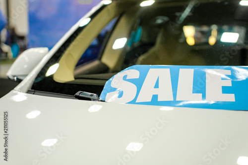 Windshield price sticker on a used white car for sale