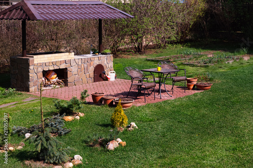 Obraz na płótnie Backyard Patio Area with Fireplace and Furniture.Green Party area. Barbacue Area. Stone.
w salonie