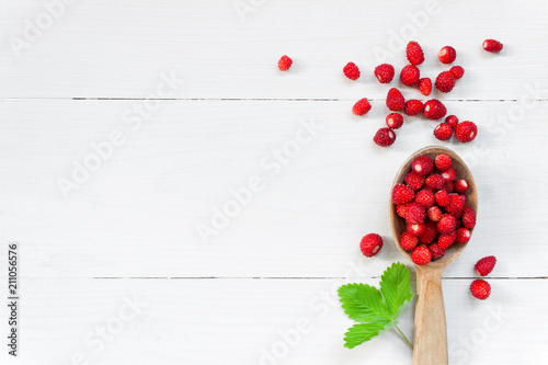Ripe wild strawberry on the white wooden table