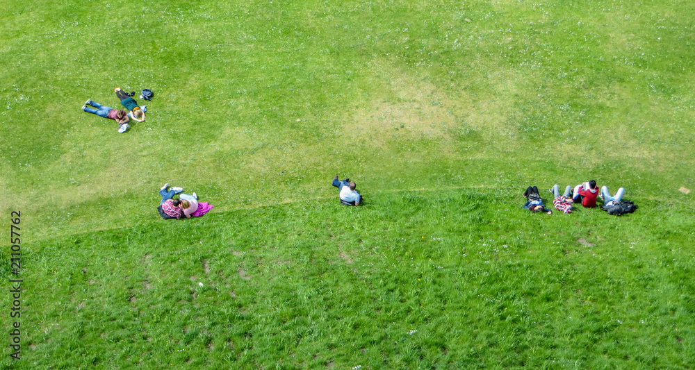 Naklejka premium People sitting on grass in a Park viewed from above