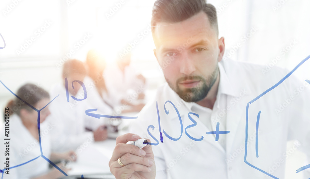 closeup of a serious scientist working with formulas closeup of a serious scientist working with formulas