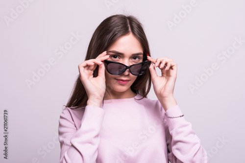 Surprised Brunette Woman in sunglasses having fun on a white background