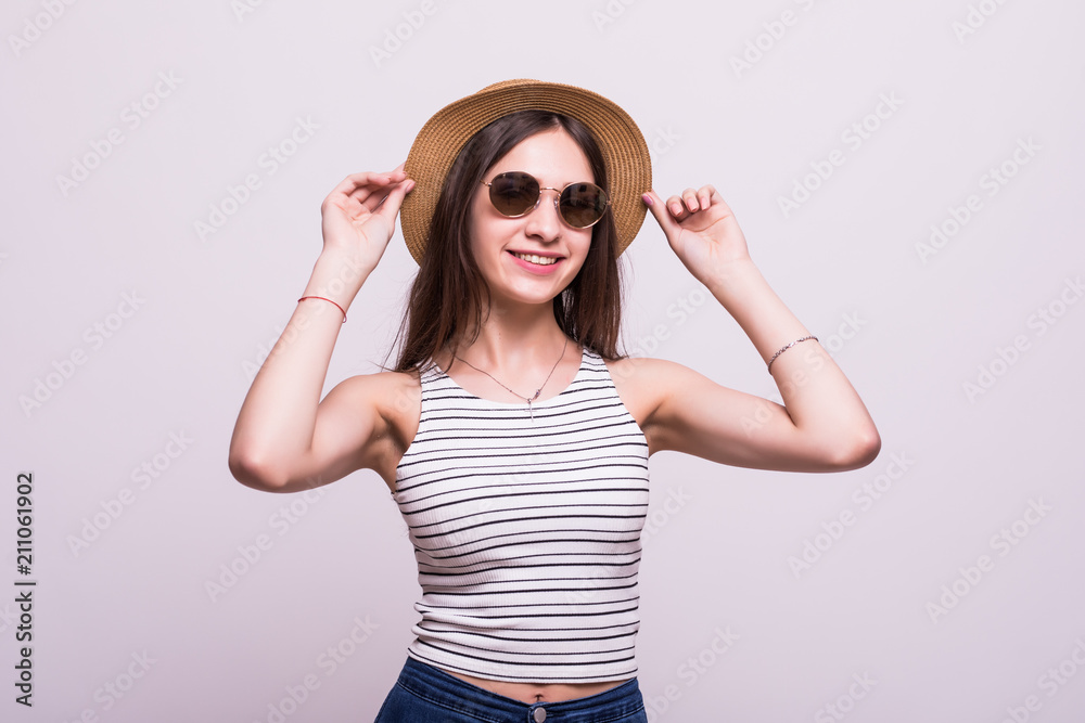 Portrait of a smiling attractive woman in summer dress and hat posing while standing and looking at camera isolated over white background Portrait of a smiling attractive woman in summer dress and hat posing while standing and looking at camera isolated over white background