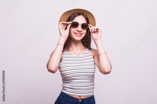 Portrait of a lovely young lady in summer dress and hat posing while standing and laughing isolated over white background © F8  \ Suport Ukraine