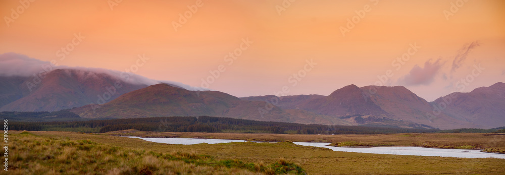 Beautiful sunset view of Connemara. Scenic Irish countryside landscape with magnificent mountains on the horizon, County Galway, Ireland.