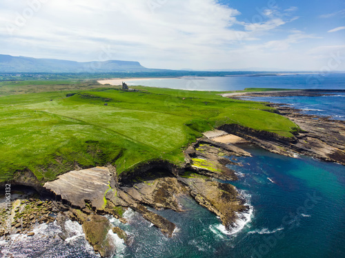 Spectacular aerial view of Mullaghmore Head with huge waves rolling ashore. Picturesque scenery with magnificent Classiebawn Castle. photo