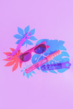 Bubble wands and sunglasses on a pastel purple background with tropical leaves and copy space. Summer activities overhead concept