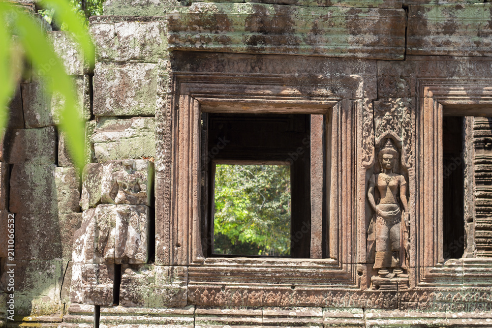 Ancient stone ruin of Banteay Kdei temple, Angkor Wat, Cambodia. Ancient temple window to green forest