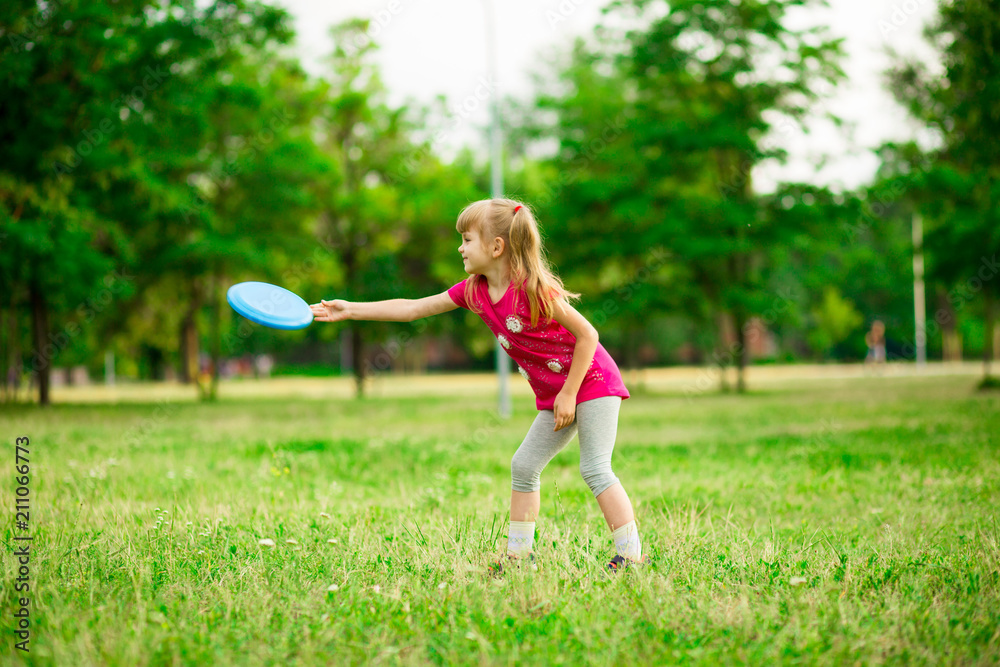 Little girl play with flying disk in motion, playing leisure activity games in summer park Little girl play with flying disk in motion, playing leisure activity games in summer park