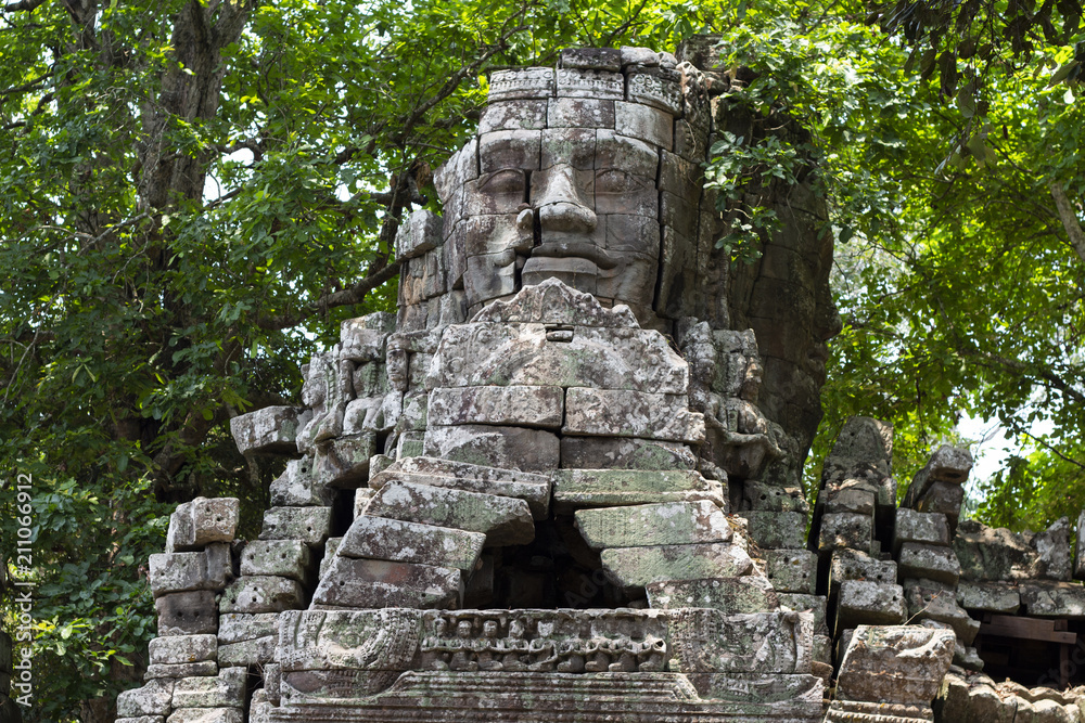 Ancient stone ruin of Banteay Kdei temple, Angkor Wat, Cambodia. Ancient temple tower with face in forest