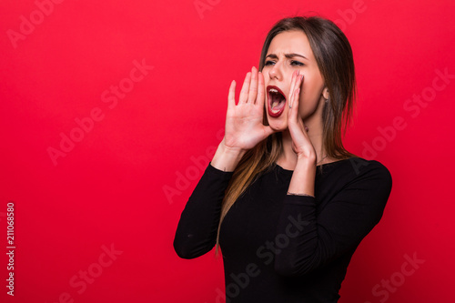 Vászonkép Portrait woman shouting over red background