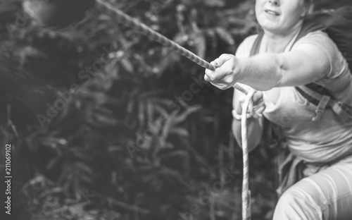 Woman climbing up a rope