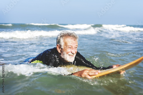 A senior man on a surfboard © Rawpixel.com