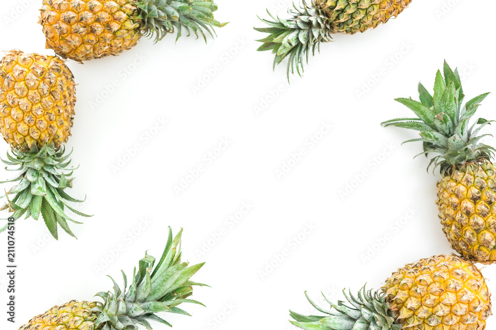Fototapeta premium Frame of pineapple fruits on white background. Flat lay, top view. Food concept with copy space