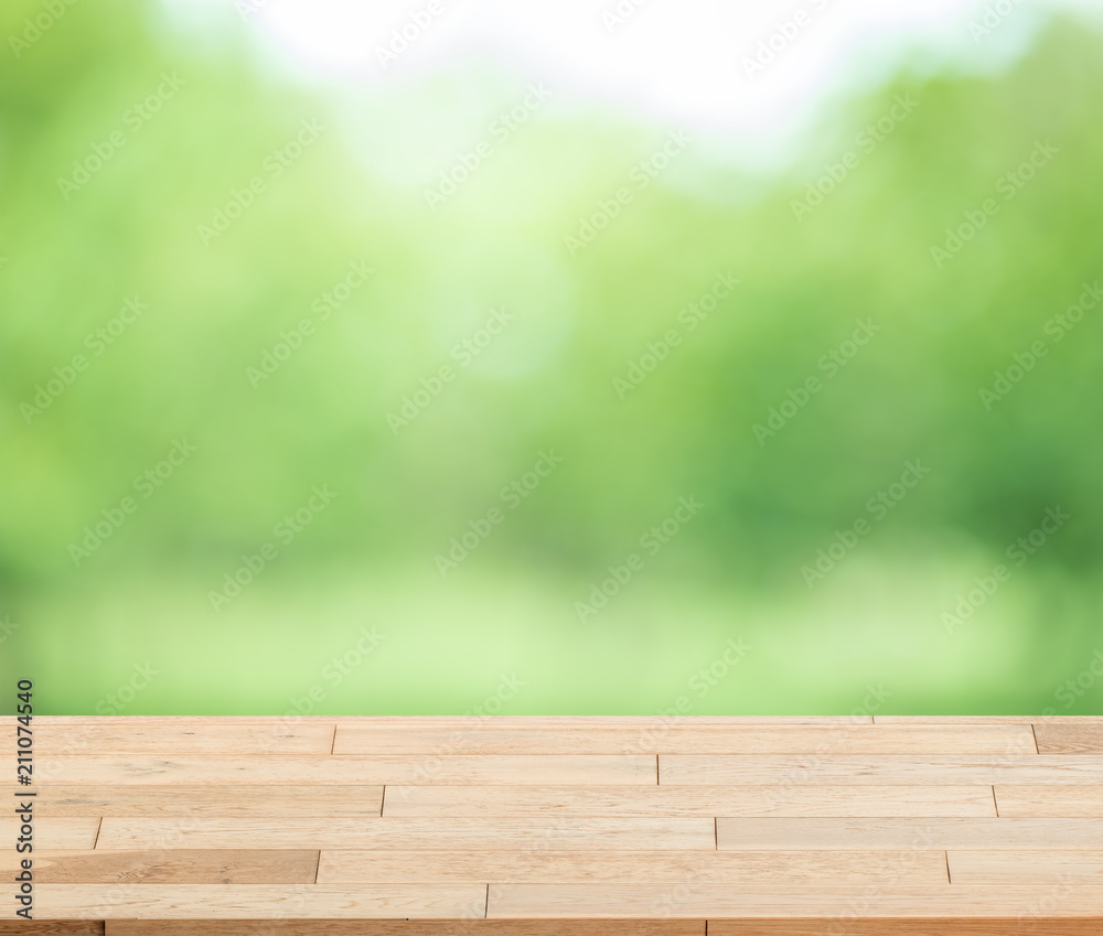 Wood table top on blur green background of trees in the park - can be used for display or montage your products. Wood table top on blur green background of trees in the park - can be used for display or montage your products.