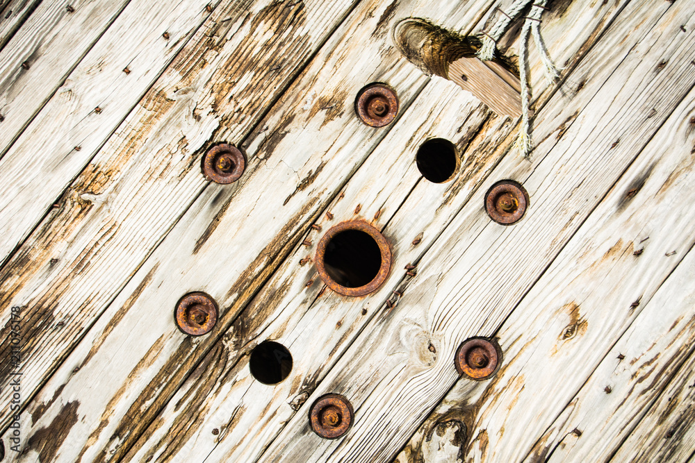 An old wooden cable spool, weather worn, with rusty metal parts and end of  a rope Stock Photo