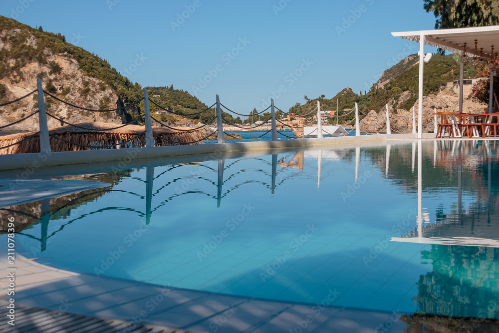 Swimming pool at luxury villa with a view of mountain and sea at beautiful morning.Empty Swimming pool terrace with mountain view. Selective focus.Empty terrace with swimming pool