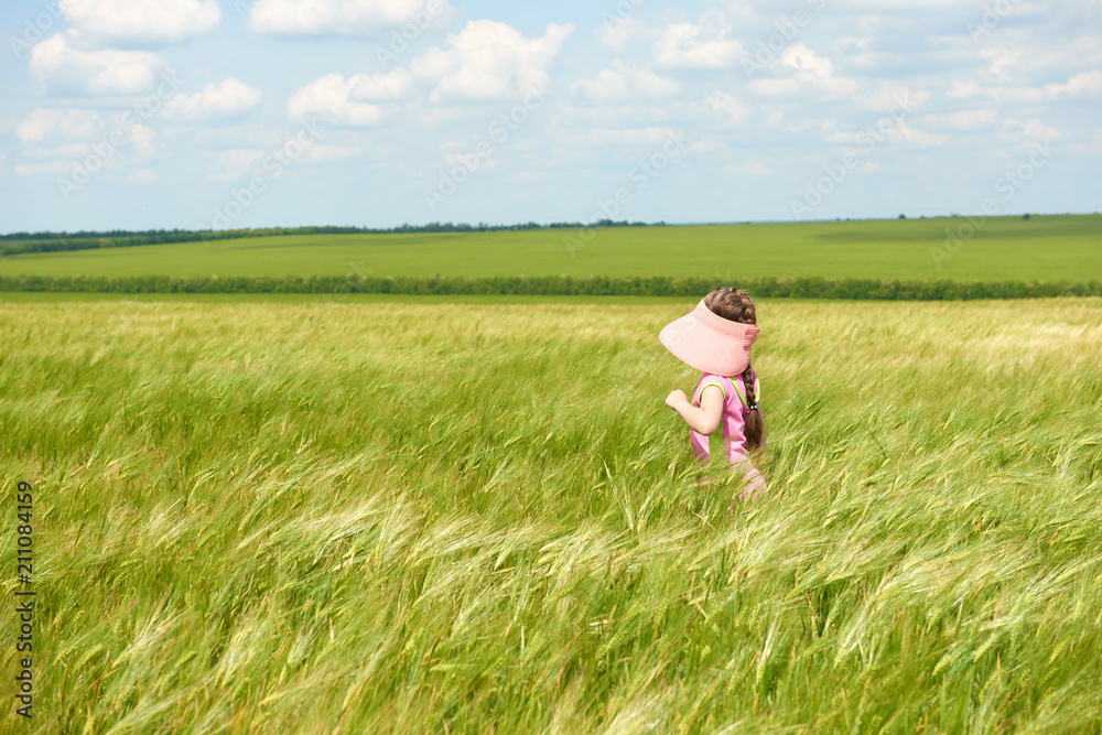 child walking through the wheat field, bright sun, beautiful summer landscape child walking through the wheat field, bright sun, beautiful summer landscape