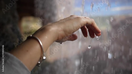 Rain waterfall imitating in a zoo a girl hand under the drops admiring feeling the water slow motion