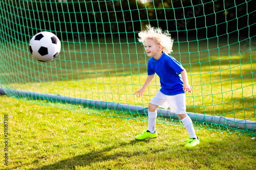 Kids play football. Child at soccer field.
