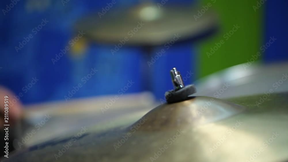 man plays percussion instruments. drums and plates close up