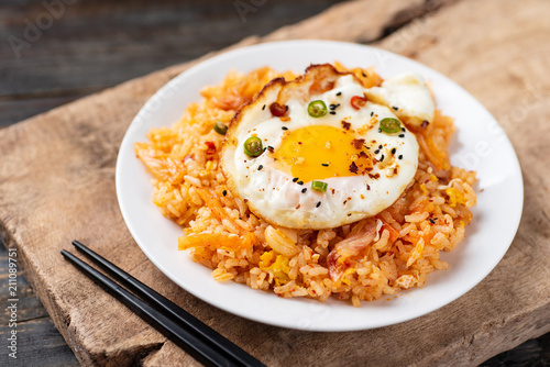 Kimchi fried rice with fried egg on top and chopsticks for eating, Korean food
