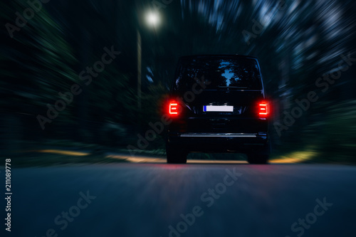 Van rides on road very fast around forest at night. Vip and luxury van go fast