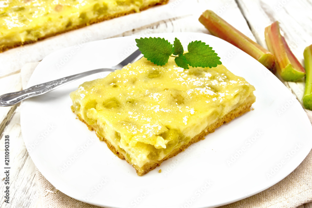 Kukhen with rhubarb and pudding in plate on wooden board Kukhen with rhubarb and pudding in plate on wooden board