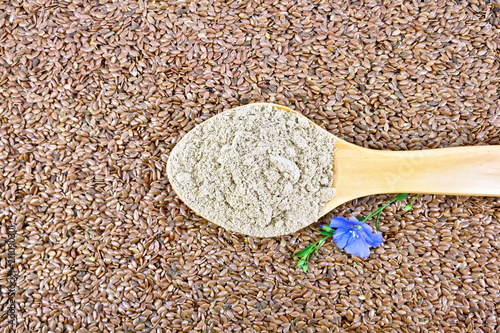 Flour linen in wooden spoon with flower on seeds
