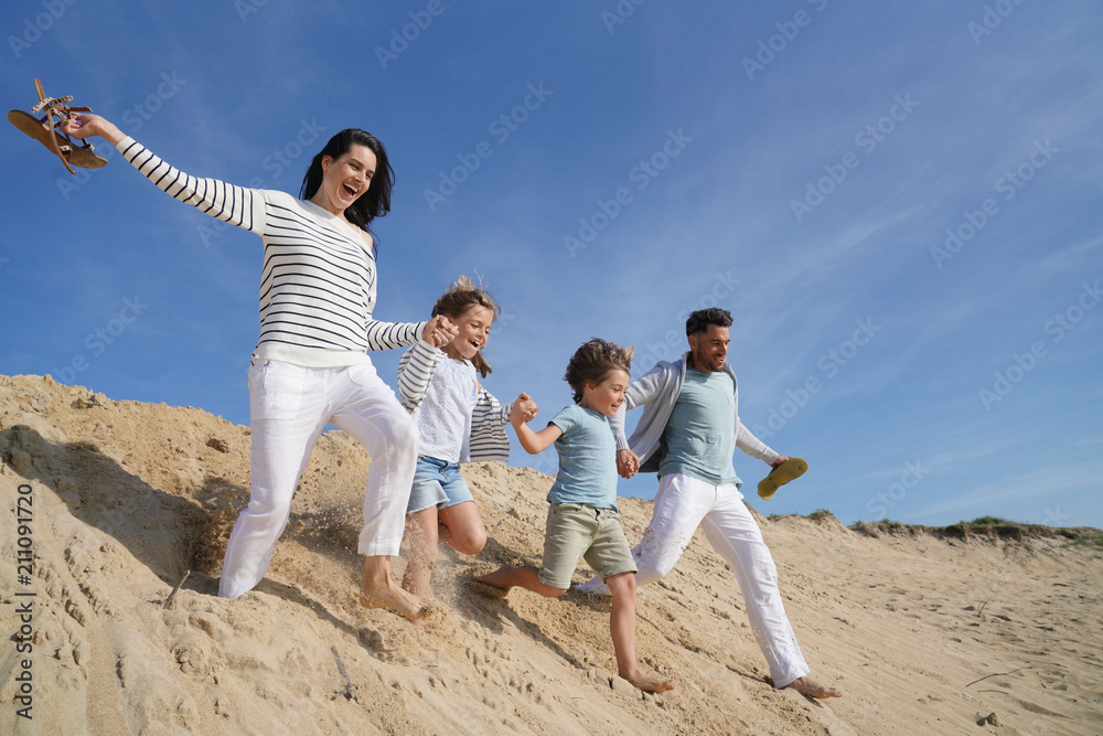 Family running down sand dune Family running down sand dune