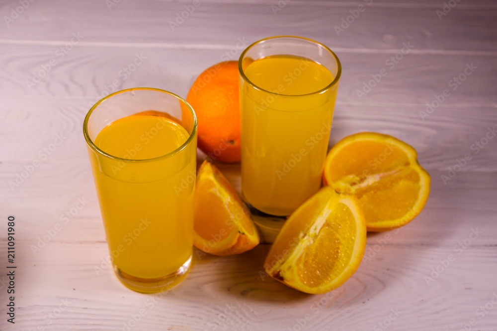 Oranges and glasses with orange juice on a wooden table Oranges and glasses with orange juice on a wooden table