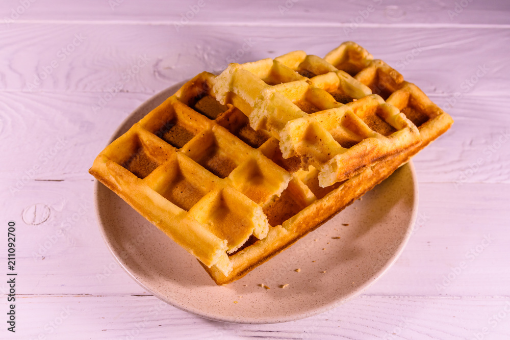 Ceramic plate with belgian waffles on wooden table Ceramic plate with belgian waffles on wooden table