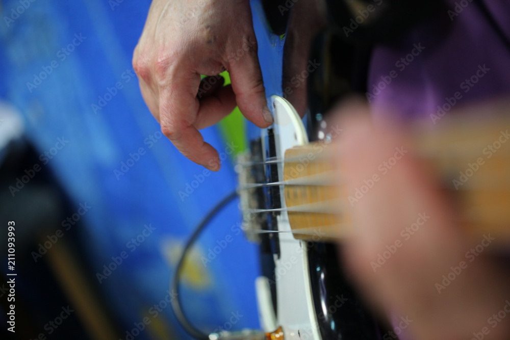 hands of a man playing an electric guitar hands of a man playing an electric guitar