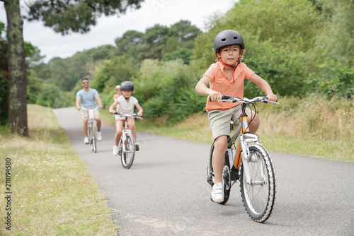 Kids with parents riding bikes in countryside