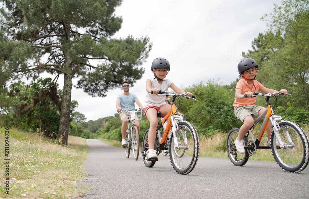 Kids with parents riding bikes in countryside Kids with parents riding bikes in countryside