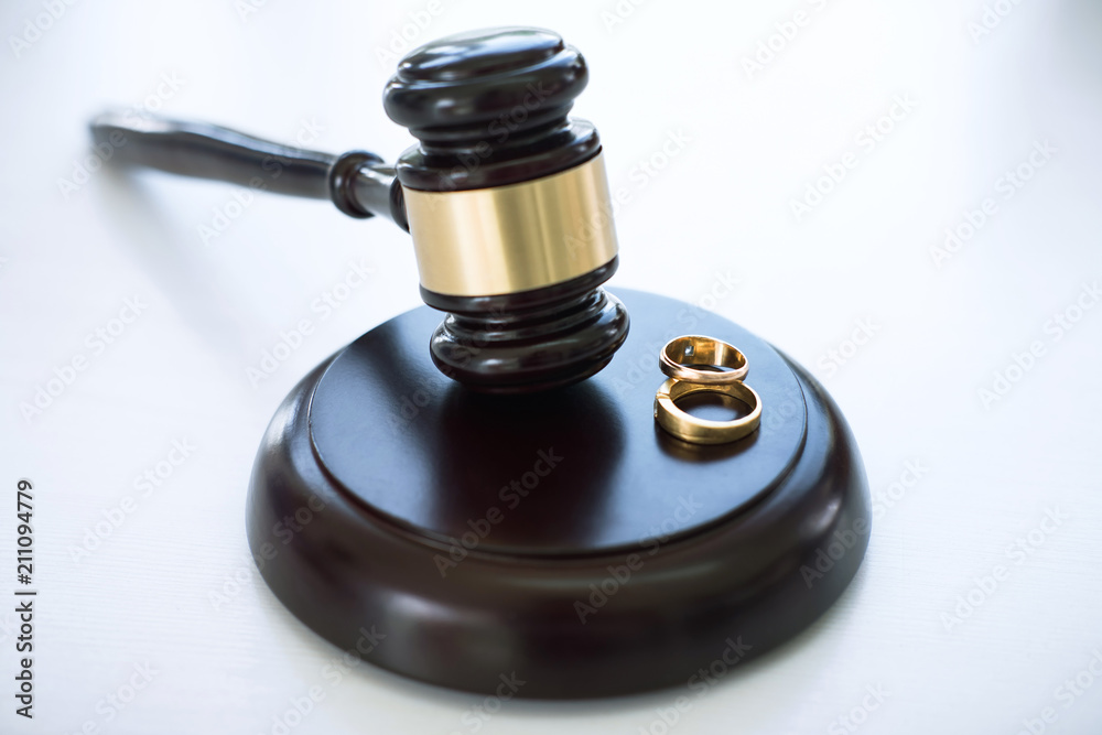 Close up of Judge gavel deciding on marriage divorce and two golden marriage ring Close up of Judge gavel deciding on marriage divorce and two golden marriage ring