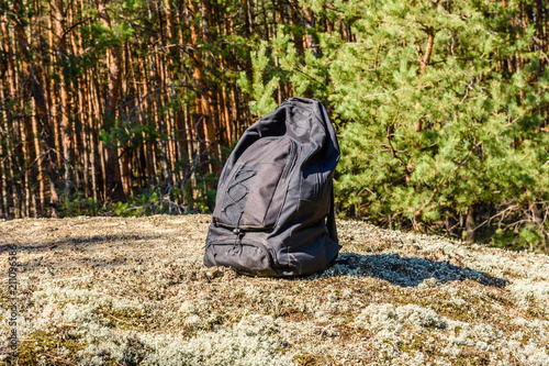 Backpack on a ground in a coniferous forest © ihorbondarenko