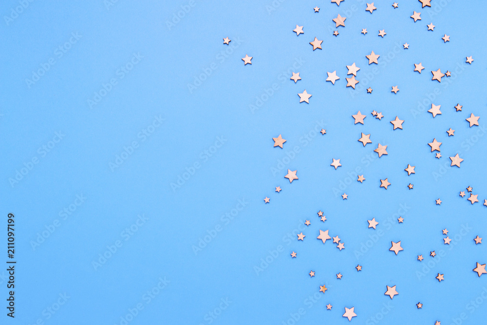 Decorative stars on a blue background. Concept of the night sky. Can be used as wallpaper or background. Flat lay, top view Decorative stars on a blue background. Concept of the night sky. Can be used as wallpaper or background. Flat lay, top view
