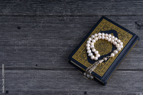 Kuala Lumpur, Malaysia- December 4, 2017: Closeup of Holy Quran/Koran with beads or Tasbih/Rosary over wooden background.Selective focus and crop fragment.