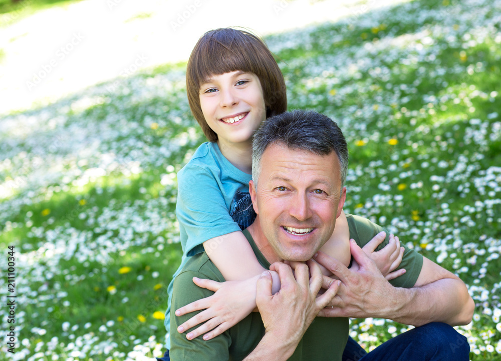 Portrait of father with his son having fun in summer park. Piggyback. Family fun. Happy boy playing with dad summer nature outdoor Portrait of father with his son having fun in summer park. Piggyback. Family fun. Happy boy playing with dad summer nature outdoor