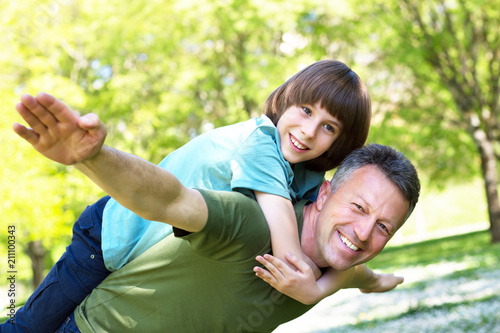 Portrait of father with his son having fun in summer park. Piggyback. Family fun. Happy boy playing with dad summer nature outdoor photo