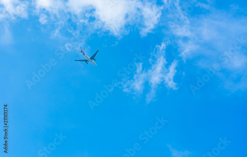 Airplane on blue sky and white clouds. Commercial airline flying on blue sky. Travel flight for vacation. Aviation transport.