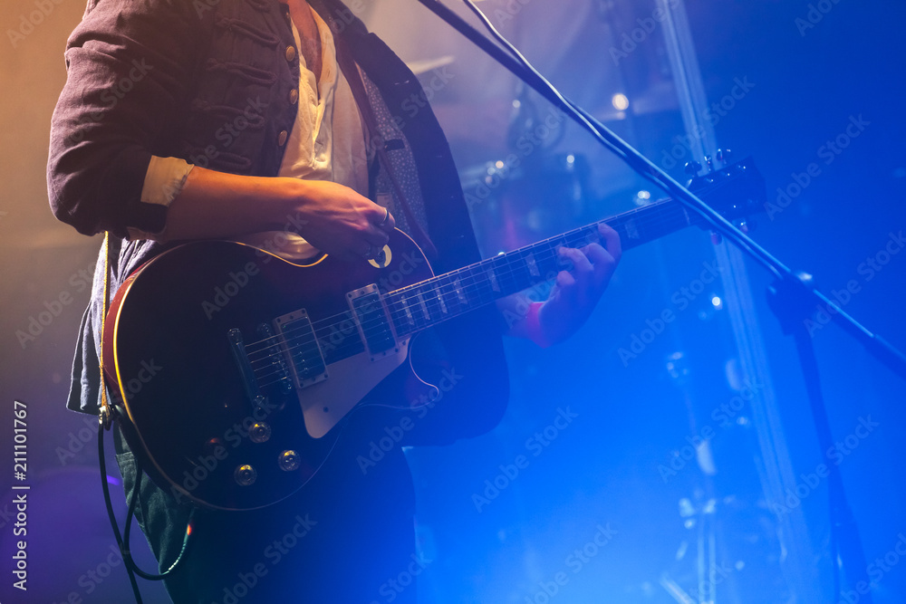 Naklejka premium Guitarist on stage plays on electric guitar