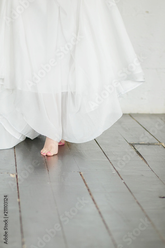 the bride walks barefoot on the wooden floor