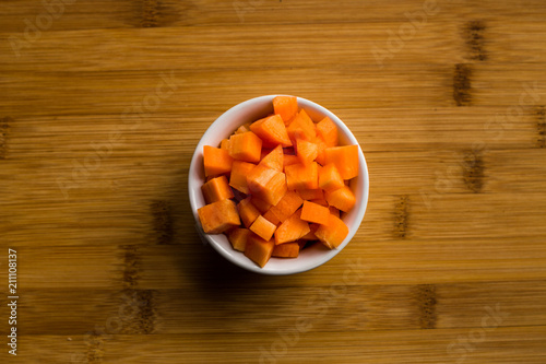 Diced carrots on wooden chopping board