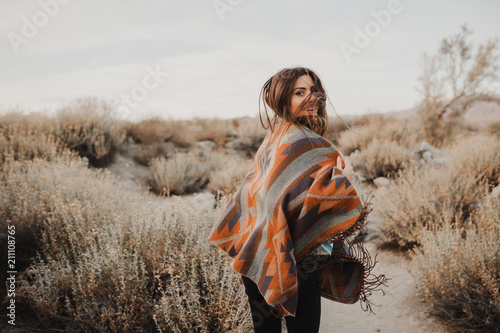 Boho woman with windy hair. Hipster girl in gypsy look, young traveler in the desert nature.