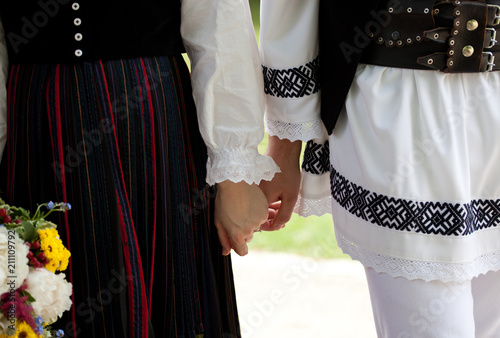 bride wearing a traditional hungarian wedding dress and groom in a traditional romanian costume - intereethnic marriage photo